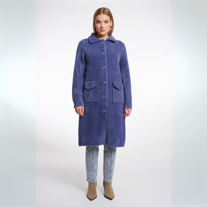 Woman wearing a long blue coat on a white background