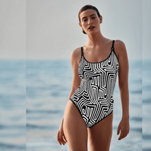 Load image into Gallery viewer, A model standing in front of water while wearing the Rosa Faia Marinet Swimsuit. 
