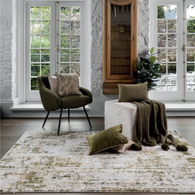 Load image into Gallery viewer, Promo shot of a room with a chair and a pouffe that have cushions sitting on each and a throw draped over the pouffee
