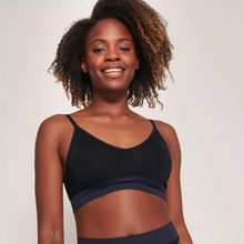 Load image into Gallery viewer, A close up picture of a model smiling while wearing the Sloggi Ever Infused Aloe Bralette. 
