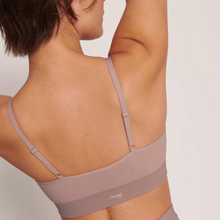 Load image into Gallery viewer, A close up of a model showing the back of the Sloggi Ever Infused Aloe Bralette in Mauve with her arms lifted, looking to the right.
