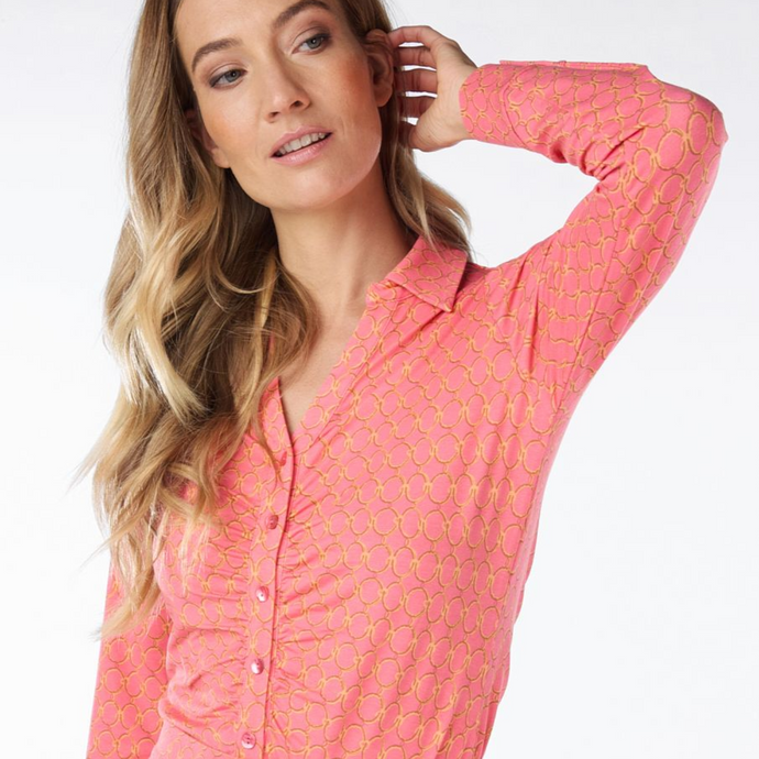 female model wearing Esqualo blouse in coral colour with hand on hair
