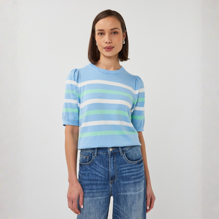 Woman wearing a light blue striped sweater and jeans on a white background