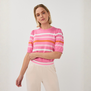 Woman wearing a pink striped sweater against a white background