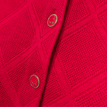 Load image into Gallery viewer, Close-up of the Castle Poppy Cardigan on a mannequin, highlighting the intricate diamond pattern, button detailing and textured knit.
