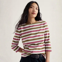 Load image into Gallery viewer, A woman wearing a three-quarter sleeve striped top with horizontal bands of olive green, dusty pink, and off-white, paired with dark trousers and a black belt, set against a plain light background.
