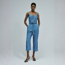 Load image into Gallery viewer, Woman wearing a blue denim jumpsuit on a plain background
