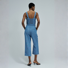 Load image into Gallery viewer, Woman wearing a blue denim jumpsuit on a plain background
