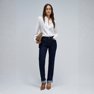 Lady in jeans and a white shirt on grey background 