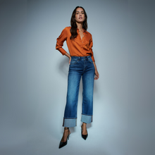 Load image into Gallery viewer, Lady in Jeans with Heels and Orange blouse on Grey background 
