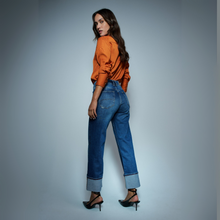 Load image into Gallery viewer, Lady in jeans with orange blouse rear on grey background 
