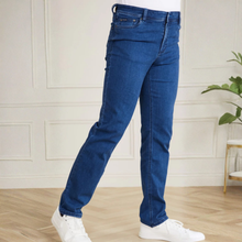 Load image into Gallery viewer, Person wearing blue jeans and white sneakers in a room with a light-colored wall and wooden floor.
