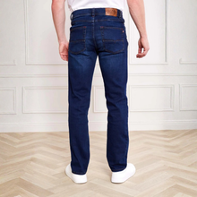 Load image into Gallery viewer, Person wearing blue jeans standing on a wooden floor with a white paneled wall background
