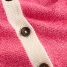 Load image into Gallery viewer, Close-up of a pink knit cardigan with a cream ribbed placket and dark brown buttons.
