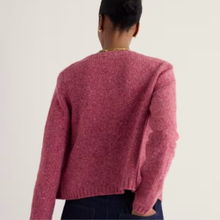 Load image into Gallery viewer, A person shown from the back wearing a textured knit sweater in a dusty rose pink color, paired with dark blue jeans, against a plain off-white background.
