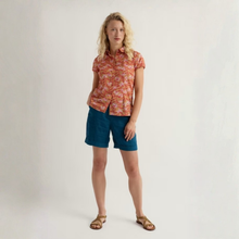 Load image into Gallery viewer, Woman wearing a patterned shirt and blue shorts on a plain background
