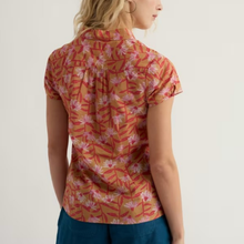 Load image into Gallery viewer, Woman wearing a short-sleeve floral shirt with red and pink patterns on a plain background
