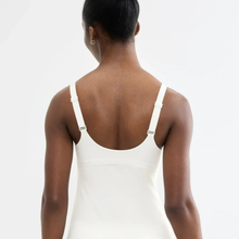 Load image into Gallery viewer, Rear view of a model wearing a white camisole tank top with adjustable shoulder straps, set against a plain white background.
