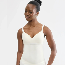 Load image into Gallery viewer, A woman modeling a cream-colored, strapless V-neck shapewear bodysuit against a plain white studio background.

