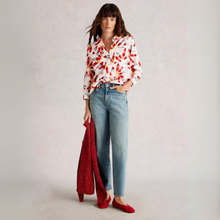 Load image into Gallery viewer, Woman wearing a colorful blouse, light blue jeans, and red shoes on a plain background
