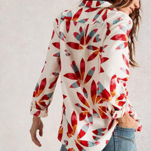 Load image into Gallery viewer, Woman wearing a colorful floral patterned shirt against a plain background
