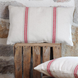 Close up of cushion facing and on side with crate and stone wall 