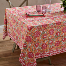 Load image into Gallery viewer, Floral patterned tablecloth on a dining table with pink glasses and green plates.
