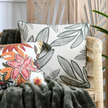 Load image into Gallery viewer, Two decorative throw pillows styled on a wicker chair with a dark gray blanket. The larger pillow features a cream background with a dark gray leaf pattern, and the smaller pillow features a white background with a pink, orange, and yellow floral design.
