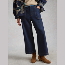 Load image into Gallery viewer, Low shot of Model posing, Wearing White Stuff Tia Dark Denim in dark denim, with a light grey background.
