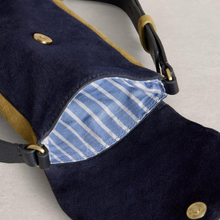 Load image into Gallery viewer, Navy blue bag with gold buttons and a striped interior on a light gray background
