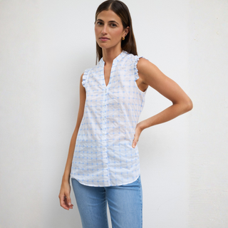 Woman wearing a light blue patterned sleeveless blouse against a white background