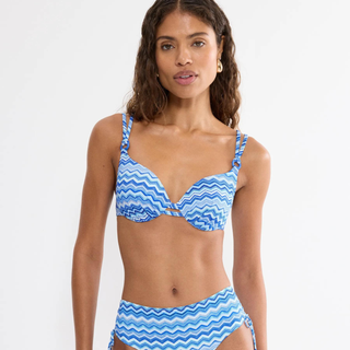 Woman wearing a blue and white striped bikini against a white background