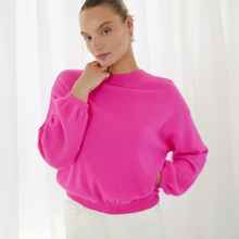 Load image into Gallery viewer, Person wearing a bright pink sweater against a white background
