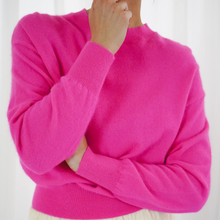 Load image into Gallery viewer, Person wearing a bright pink sweater on a white background
