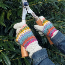 Load image into Gallery viewer, A person wearing colorful striped knit gardening gloves uses hedge shears on green leaves outdoors.
