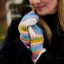 Load image into Gallery viewer, A close-up of a person wearing a pair of hand-knit multicolor mittens with horizontal stripes of purple, blue, green, yellow, orange, and white, paired with a black coat.
