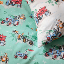 Load image into Gallery viewer, A close-up of a printed bedding set featuring a light mint green and white fabric with a cartoon tractor pattern, including a pillowcase and a folded sheet.

