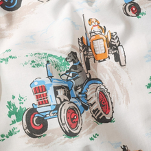 Load image into Gallery viewer, Close-up of a fabric surface printed with cartoon tractors and dogs driving them. The visible design includes a blue tractor with a black dog driver and an orange tractor with a light brown dog driver, on an off-white background with green and tan farm-style accents.
