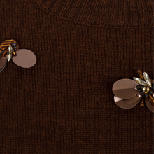 Load image into Gallery viewer, Close-up of a dark brown ribbed knit sweater featuring decorative metallic flower and bee embellishments on the chest.
