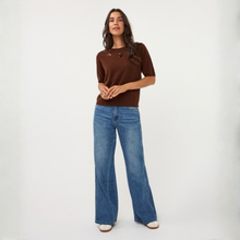 Load image into Gallery viewer, A woman modeling a brown short-sleeve knit top and wide-leg blue jeans against a plain white studio background.
