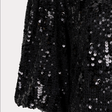 Load image into Gallery viewer, Close-up of a black sequined fabric with silver sequins and a textured knit base, shown against a light gray background.
