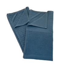 Load image into Gallery viewer, Folded blue textured towel on a white background
