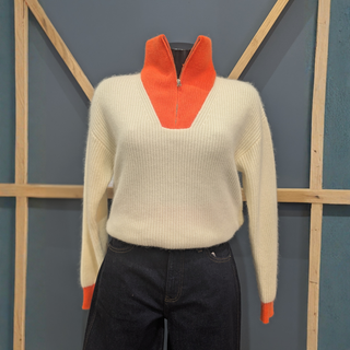 Front of Twns The Label Breckenridge White/Neon Orange, with a wooden and blue background.