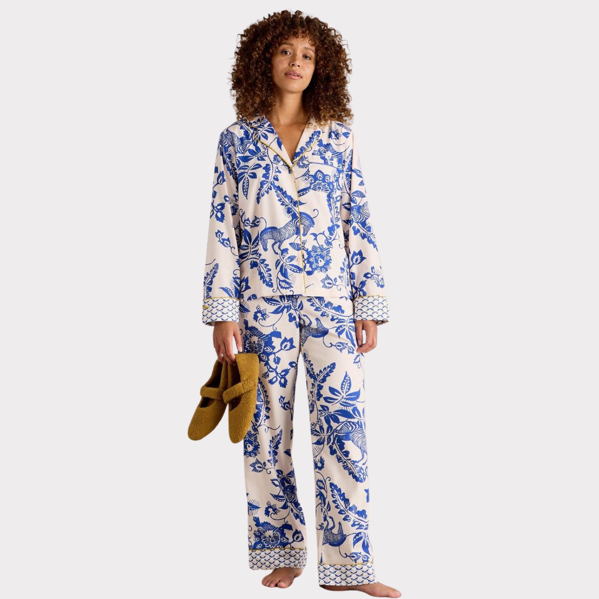 Woman wearing a blue and white floral pajama set on a white background