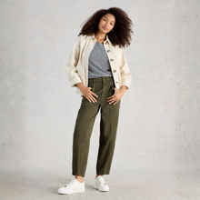 Load image into Gallery viewer, Woman wearing a cream jacket, striped shirt, green pants, and white sneakers on a gray background
