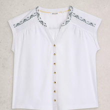 Load image into Gallery viewer, White blouse with black embroidery and gold buttons on a light gray background
