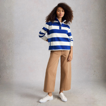 Load image into Gallery viewer, Woman wearing a blue and white striped shirt with beige pants against a gray background
