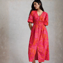 Load image into Gallery viewer, Woman wearing a pink and orange patterned dress against a plain background

