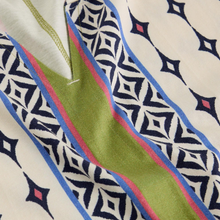 Load image into Gallery viewer, Close-up of fabric with geometric pattern and green stripe
