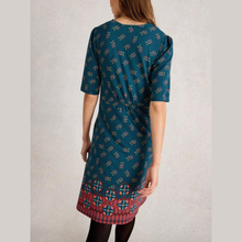 Load image into Gallery viewer, Woman wearing a teal dress with a patterned hem on a plain background
